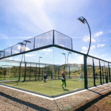 Guests enjoying a sunny outdoor padel court with scenic hill views at luxury hotel.