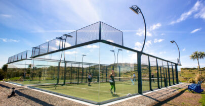 Guests enjoying a sunny outdoor padel court with scenic hill views at luxury hotel.